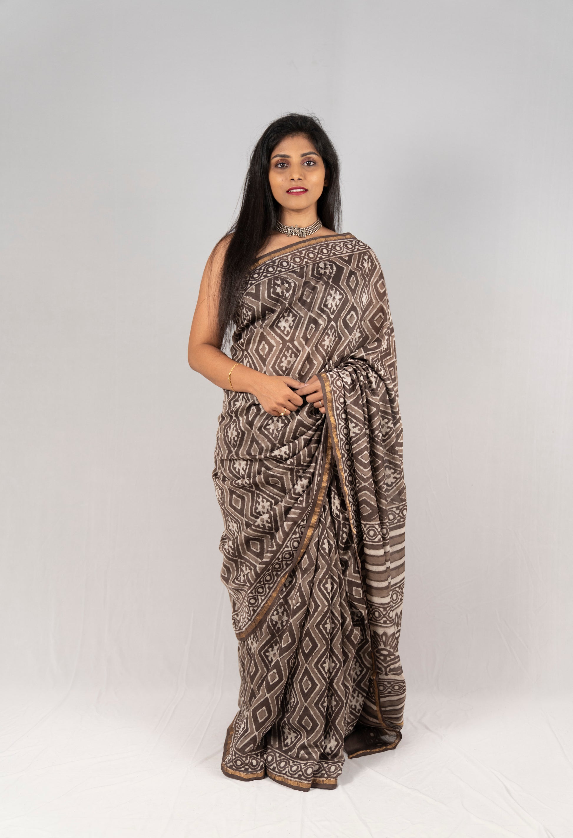 Hand block printed saree from Anemone vinkel, this brown saree and white handloom saree looks beautiful when paired with a contrasting blouse.